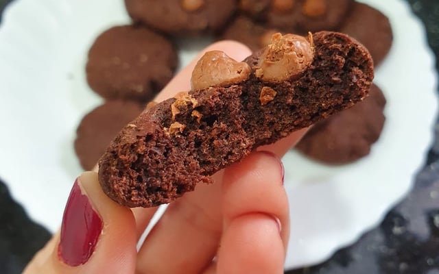 Cookies de aveia e cacau empilhados sobre superfície rústica de madeira